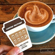 a cup of coffee with a card in front of it that says coffee factor on the side