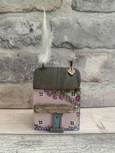 a small pink house sitting on top of a wooden table