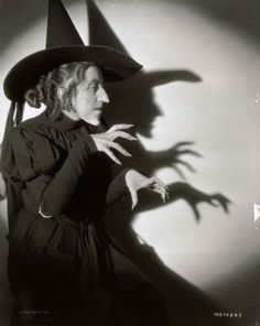 a woman wearing a witches hat and holding her hands out in front of the camera