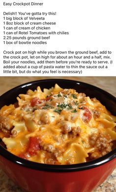 a red bowl filled with pasta and meat on top of a counter next to a menu