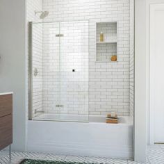 a white tiled bathroom with a walk in shower