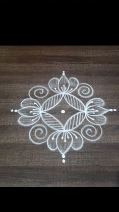 a wooden table topped with a white painted design