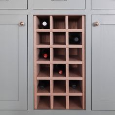 a wine rack in the corner of a kitchen with grey cabinets and white lettering that reads diy wine rack