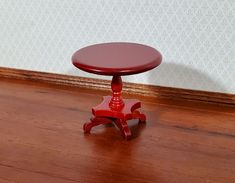 a small red table sitting on top of a wooden floor