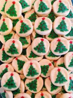 christmas tree decorated cookies are displayed on a platter