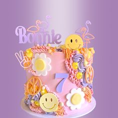 a pink cake with yellow and purple icing on it's side that says bonnie