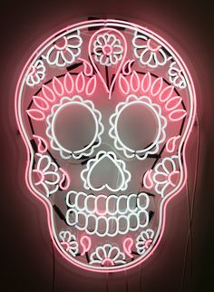 a neon sign with a skull in the middle and flowers on it's face