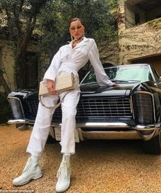 a woman sitting on the hood of a car