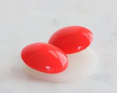 These vintage earrings are a vibrant red-orange color, crafted from high-quality plastic in a unique oval shape. The clip-on style makes them easy to wear, and their large size ensures they make a bold statement. These earrings are perfect for those who love to add a pop of color to their outfits. Their vintage charm adds a touch of nostalgia, making them a must-have for any vintage jewelry collector. Please note that due to their age, they may show some signs of wear. The earrings measure 1 1/4 inches by 1 5/8 inches. oooooooooo **PLEASE NOTE** This is a vintage and it may show wear or need to be cleaned. **HAVE QUESTIONS?** Please convo me, I'm more than happy to answer any questions you may have. **SATISFACTION Guaranteed If for any reason you don't love your purchase, please send it ba Red Orange Color, Earrings Vintage, Vibrant Red, Vintage Charms, Vintage Earrings, Oval Shape, Clip On, Etsy Vintage, Clip On Earrings