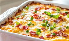 a casserole dish with bacon, green onions and cheese