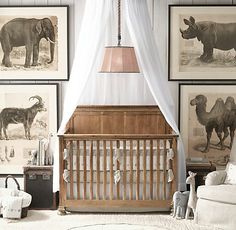 a baby crib with pictures on the wall behind it and an elephant in the background