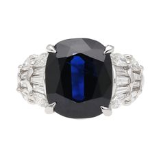 A stunning platinum ring presenting a 7.25 CT cushion-cut sapphire. The gems mesmerizing deep shade of blue catches the eye of any who come across it. The sapphire is accompanied by 10 tapered baguette-cut diamonds as well as 8 marquise-cut diamonds along the sides. Both gems complement each other well, due to the high contrast between the two. This ring weighs a total of 10.21 grams. Size 7 3/4 and adjustable.    Details:  Item Type:  Engagement Ring Metal: Platinum 900 Size: 7 3/4 (adjustable) Luxury Gia Certified Baguette Cut Sapphire Ring, Formal Sapphire Ring With Cushion Diamond Cut, Formal Sapphire Ring With Cushion Cut, Luxury Sapphire Ring With Brilliant And Baguette Cuts, Luxury Platinum Octagon Sapphire Ring, Luxury Octagon Sapphire Ring In Platinum, Luxury Octagon Sapphire Platinum Ring, Luxury Sapphire Baguette Cut Ring, Luxury Octagon Brilliant Cut Sapphire Ring