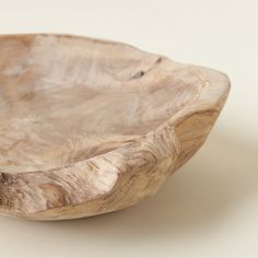 a wooden bowl sitting on top of a white table