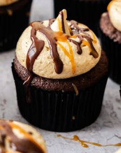 chocolate cupcakes with peanut butter frosting and caramel drizzle on top