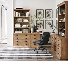 an office with wooden furniture and pictures on the wall