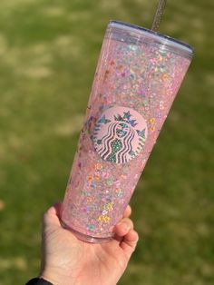 a hand holding a pink glitter starbucks cup