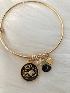 Leo Handmade Fine Brass Zodiac Charm Bracelet & Zodiac Gemstone  with 20kt GOLD Plating        Leo *Onyx (Semi Precious Zodiac Stone) *July 23 - August 22 *Faithful,Intuitive, Generous *Cubic Zirconia Stars  -Lead Free -Nickle Free -Cadmium Free -HANDMADE -Expandable from 2" to 3.5" -The bangle expands to fit just about any wrist, simply squeeze the bangle after sliding it over your hand to tighten it  SIMPLE AND BEAUTIFUL SHIPS SAME DAY VIA USPS Adjustable Gold Celestial Charm Bracelet, Gold Celestial Charm Bracelet As A Gift, Zodiac Sign Bracelet Jewelry Gift, Gold Zodiac Sign Bracelet, Gold Spiritual Bracelets With Zodiac Sign, Gold Celestial Bracelet For Gift, Celestial Gold Bracelet As Gift, Celestial Gold Bracelet For Gift, Celestial Style Gold Bracelet As Gift