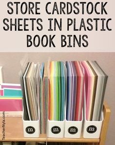 a book shelf filled with lots of books and folders next to each other on top of a wooden table