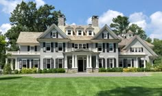 a large white house sitting on top of a lush green field