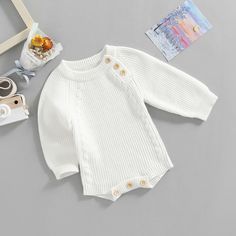 Keep your little ones cozy and cute in this Long Sleeve Kids Knit Romper! This soft knit romper features a classic design that looks adorable on any child and keeps them comfortably warm. Perfect for any occasion, this romper is sure to make your kid look stylish and feel snug. Crafted from a blend of soft cotton and durable polyester. A timeless look that suits any occasion. Covered button closure and crew-neck collar for fuss-free changes. Winter Knitted Long Sleeve Onesie, Casual Sweater For Playtime With Soft Knit, Casual Soft Knit Sweater For Playtime, Cozy White Cotton Onesie, White Long Sleeve Bubble Romper For Loungewear, White Knitted Sweater For Playtime, White Knit Sweater For Playtime, Cute White Bodysuit For Winter, Cute White Sweater For Playtime