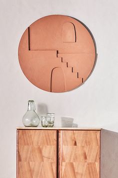 a wooden cabinet with two vases on top of it