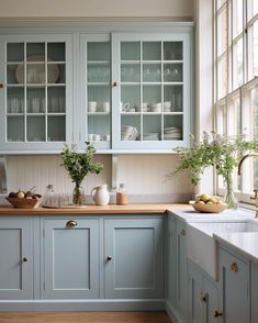 a kitchen filled with lots of blue cabinets and counter top space next to a window