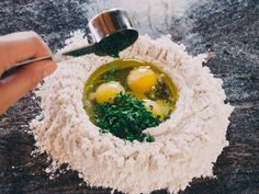 two eggs in a bowl with parsley and seasoning being mixed into the mixture