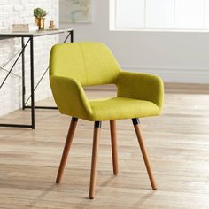 a yellow chair sitting on top of a hard wood floor next to a white wall