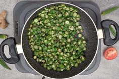 green beans are being cooked in a pan on the stove top with tomatoes and celery