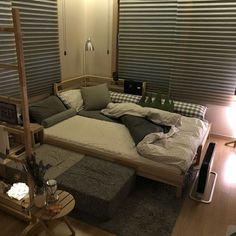 a large bed sitting on top of a wooden floor next to a window covered in blinds