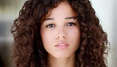 a close up of a woman with curly hair