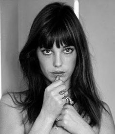 a black and white photo of a woman with her hands on her chest, posing for the camera