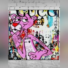 a pink cat on a brick wall with graffiti