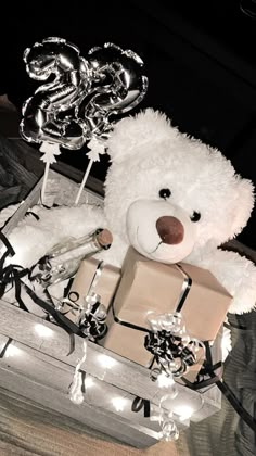 a white teddy bear sitting on top of a pile of presents