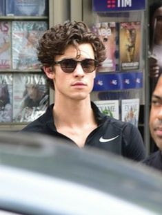 the young man is wearing sunglasses on the street