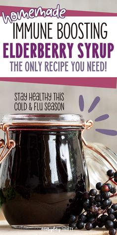 a jar filled with elderberry syrup sitting on top of a table next to berries