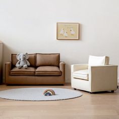 a living room filled with furniture and a teddy bear sitting on the floor next to a chair