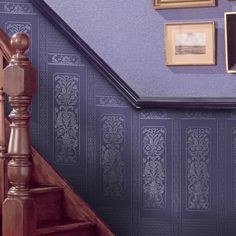 the stairs are lined with wooden handrails and framed pictures on the wall behind them