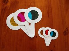 three popsicle shaped paper cut outs sitting on top of a wooden table