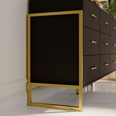 a black and gold chest of drawers next to a potted plant in a white room