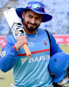 a man holding a baseball bat and wearing a blue hat