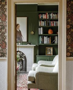 a living room filled with furniture and bookshelves next to a fire place in front of a fireplace