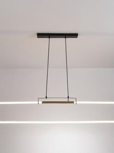 a suspended light fixture in a white room