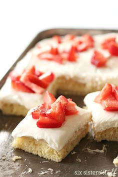 strawberry shortcake sheet cake with white frosting and sliced strawberries on the top