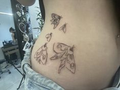 a woman's stomach with some tattoos on her belly and two birds flying over it