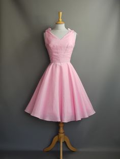 Made from a light weight linen and coupled with tie straps gives this pretty summer dress, a perfectly whimsical feel. The fitted darted bodice has an informal V neckline that dips to a low 'V' at the back. The fitted waistband, highlighted by a contrasting grey cotton piping and a full circle skirt is both flattering and relaxed in style.  The sash with a small bow detail is not included in the order. This dress is ready made and available off-the-peg in a size UK 12 (US 8/EU 40). It has been m Dig For Victory, Pretty Summer Dress, Pretty Summer Dresses, Full Circle Skirt, Full Circle Skirts, Small Bows, Candy Pink, Pink Linen, Full Circle