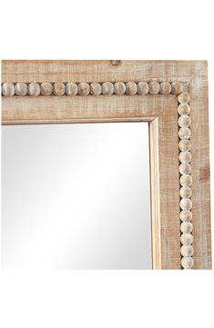 a wooden frame mirror with beaded trimmings on the edge and bottom half