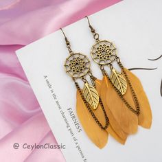 Elevate your style with these Bohemian Ethnic Dream Catcher Feather Long Earrings. Each pair boasts a delightful blend of Zinc alloy metal, shaped into a leaf, and adorned with an actual feather. These earrings, a fusion of bohemian spirit and vintage charm, bring sophistication to any ensemble. Perfect for various occasions like parties, birthdays, weddings, or daily wear, they make an excellent gift for moms, girls, ladies, friends, and daughters alike. Specifications: 👩 Gender: Women 🌼 Shap Dreamcatcher Earrings, Dream Catcher Earrings, Handmade Dreamcatcher, Boho Feathers, Long Tassel Earrings, Drop Dangle Earrings, Stunning Earrings, Boho Stil, Feather Earrings