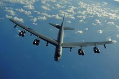 an airplane is flying in the sky with clouds and blue skies behind it, as seen from below