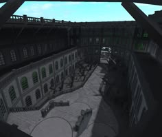 an aerial view of a courtyard with benches and tables in the center, looking down on a building